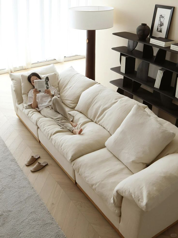 Textured linen and warm wood styling details beside a beige sofa